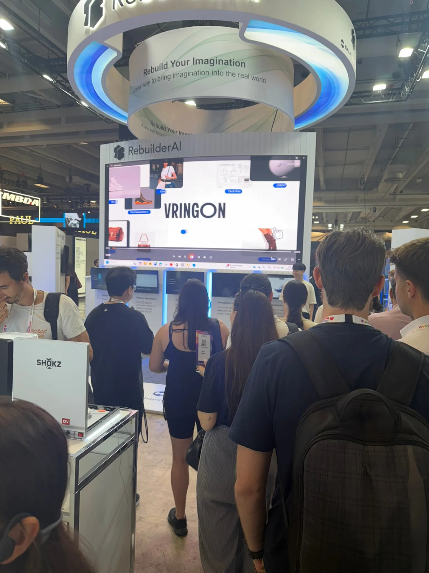 VivaTech 전시 부스 앞에서 화면을 보는 관람객